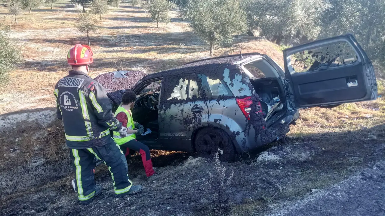 Los bomberos inspeccionan el todoterreno tras liberar a sus ocupantes (FOTO: cedida)